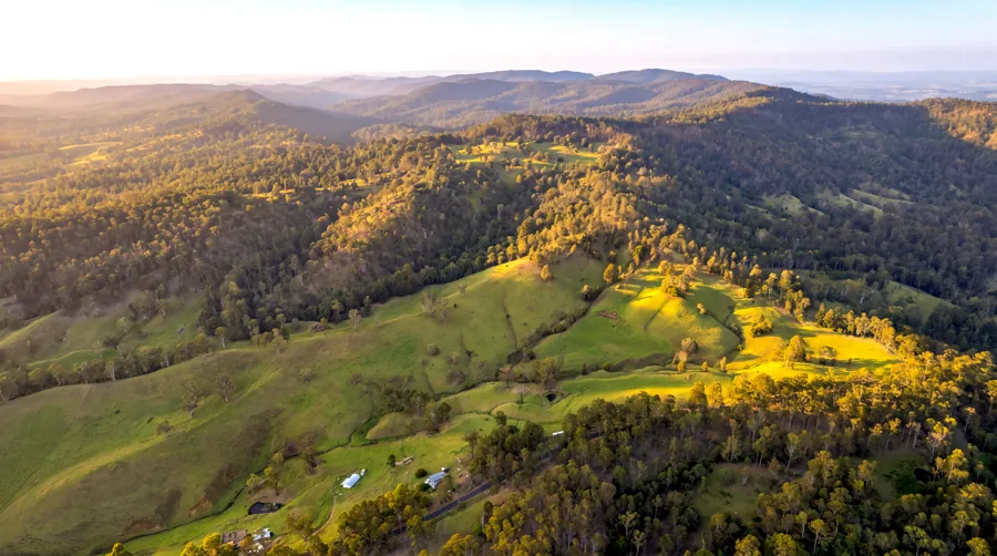Aerial view of open pasture and wooded ridgelines