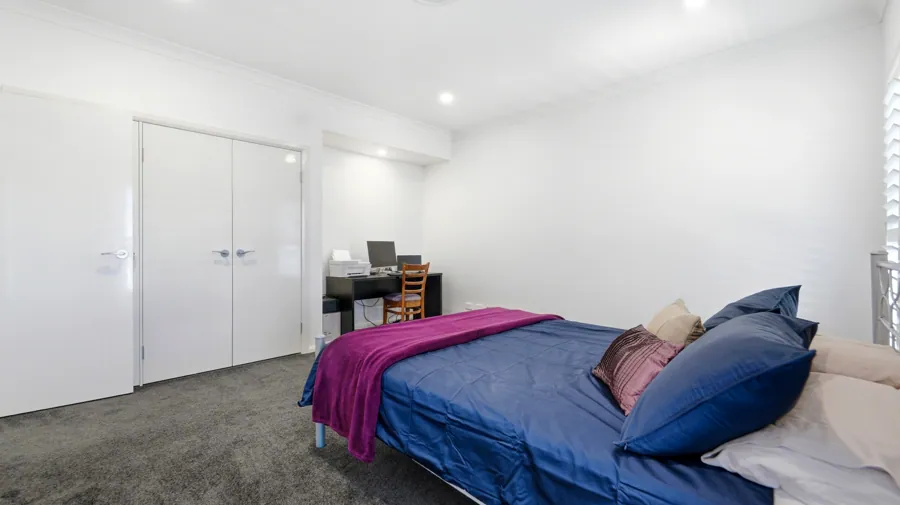 Carpeted bedroom with a ceiling fan