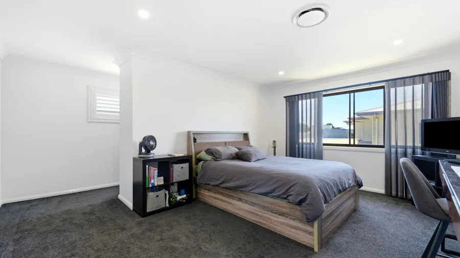 Carpeted bedroom with a wide window