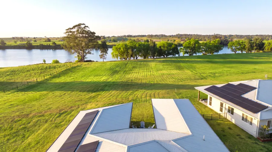 Elevated view across the home and lawn towards the river