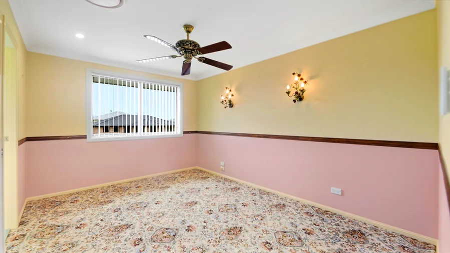 Bedroom with a ceiling fan and coloured wall detail