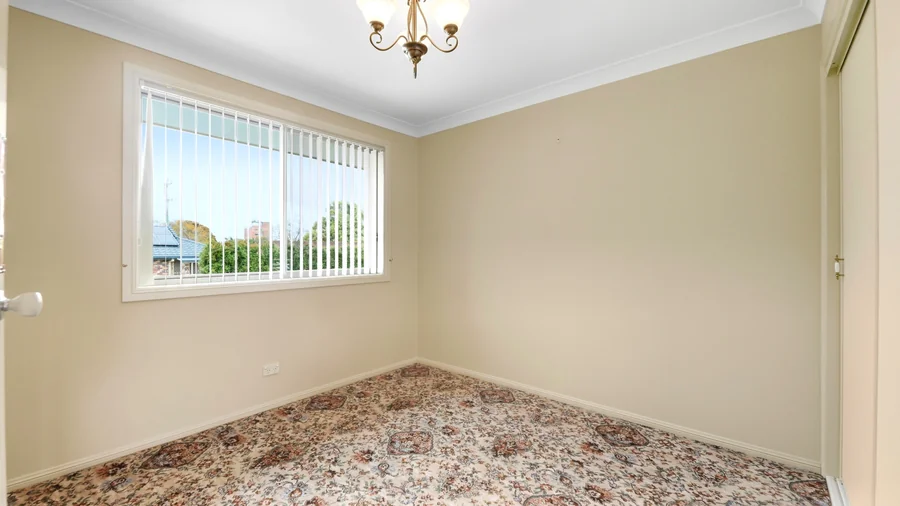 Second carpeted bedroom with a wide window
