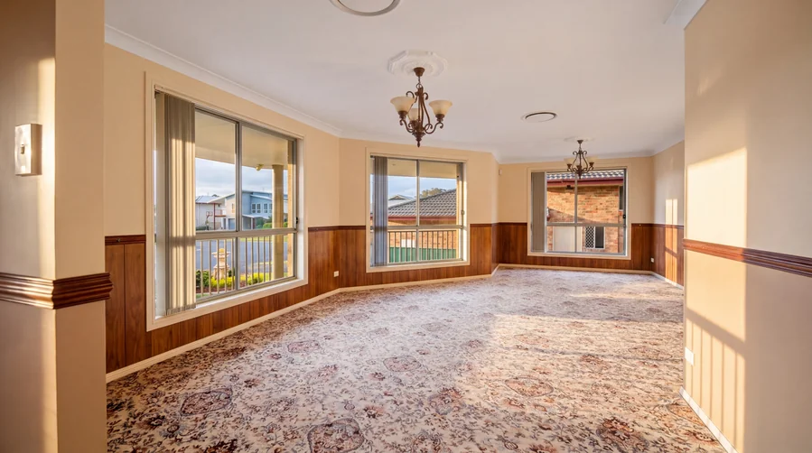 Carpeted living space overlooking the front lawn