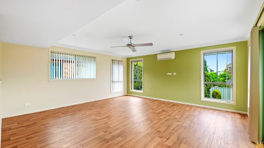 Additional living space with a ceiling fan and large windows